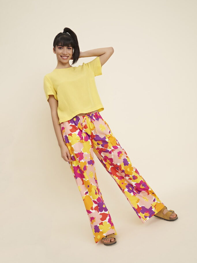 A ray of sunshine. Our Aili blouse has short sleeves, a round neck and a central zip opening at the back. The hem at the bottom and sleeves is high and the bottom has two very comfortable slits. 
