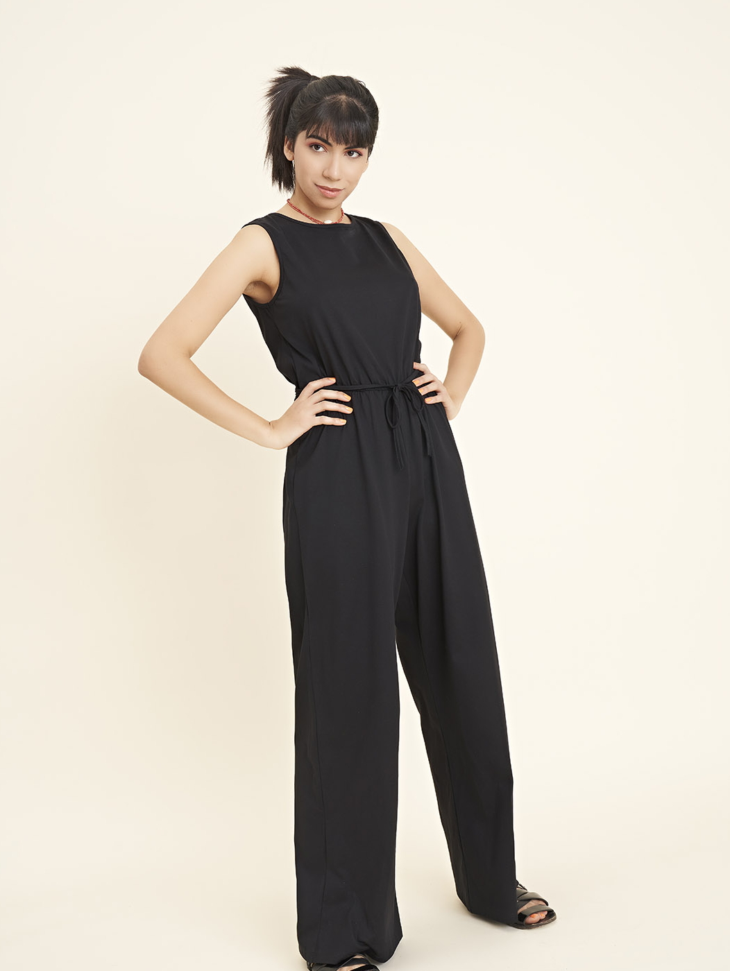 One garment for all occasions. Nali is our sleeveless jersey jumpsuit. It has an elasticated waist, which is also highlighted by the drawstring to be used as a belt. The front has a round neck, the back has a raw cut opening closed by a fabric drawstring.