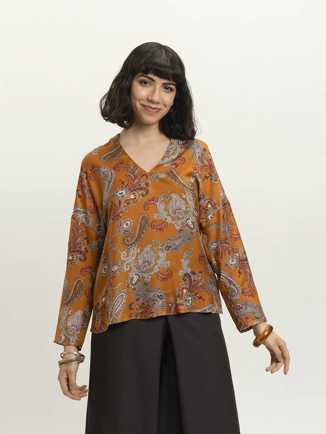A blouse that can instantly transport you to distant worlds: how? Simply by wearing the unlined and ultra-light Valpantena ? with long sleeves, open mandarin collar on the V-neck and dropped shoulder ? and letting its ethnic patterned silk fabric envelop you!